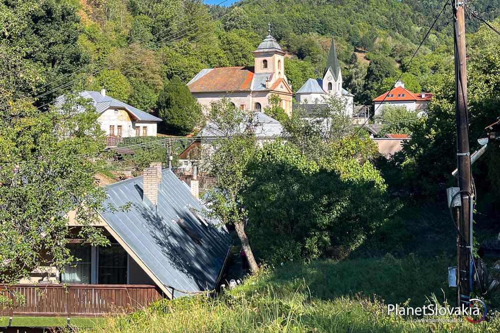 Od evanjelického a katolíckeho kostola v Banskej Hodruši sa chodníčkom okolo domu v popredí dostanete priamo k baníckej klopačke.