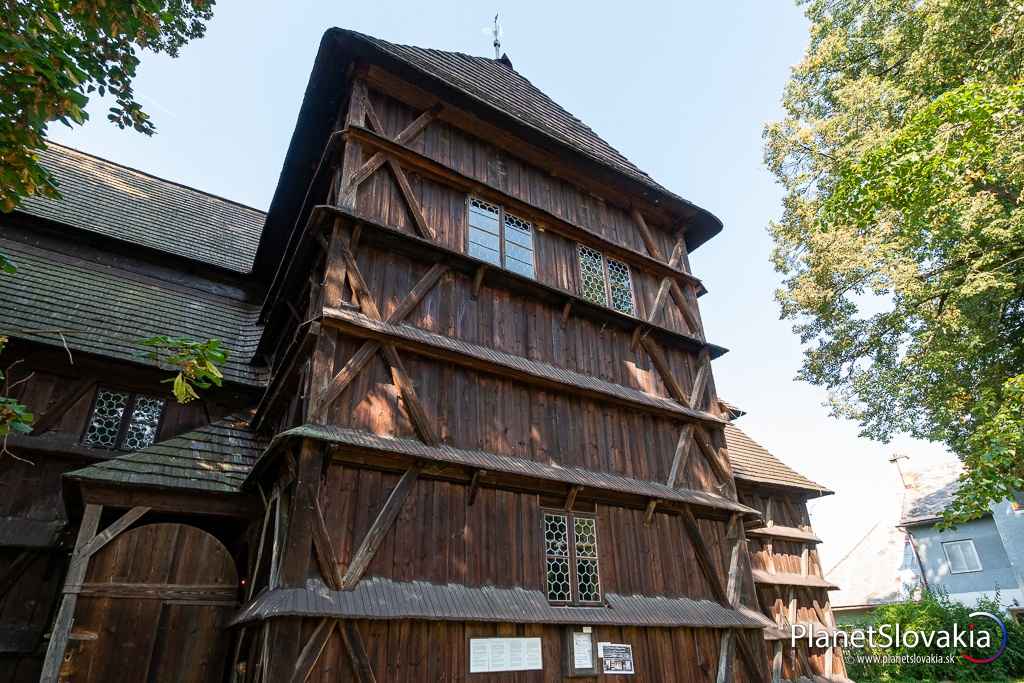 Bočný pohľad na drevené rímsy a originálne okná dreveného kostola v Hronseku.