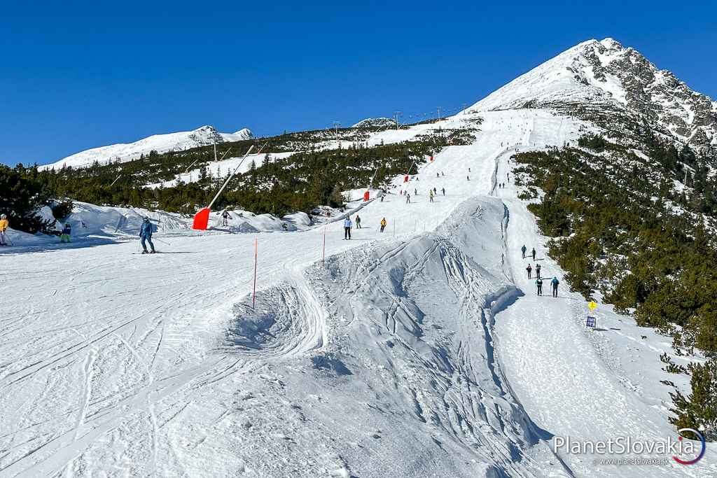 Pohľad na jednu zo zjazdovke v lyžiarskom stredisku na Štrbskom Plese. Zároveň si vpravo možno všimnúť skitouringovú výstupovú trasu k chate pod Soliskom.