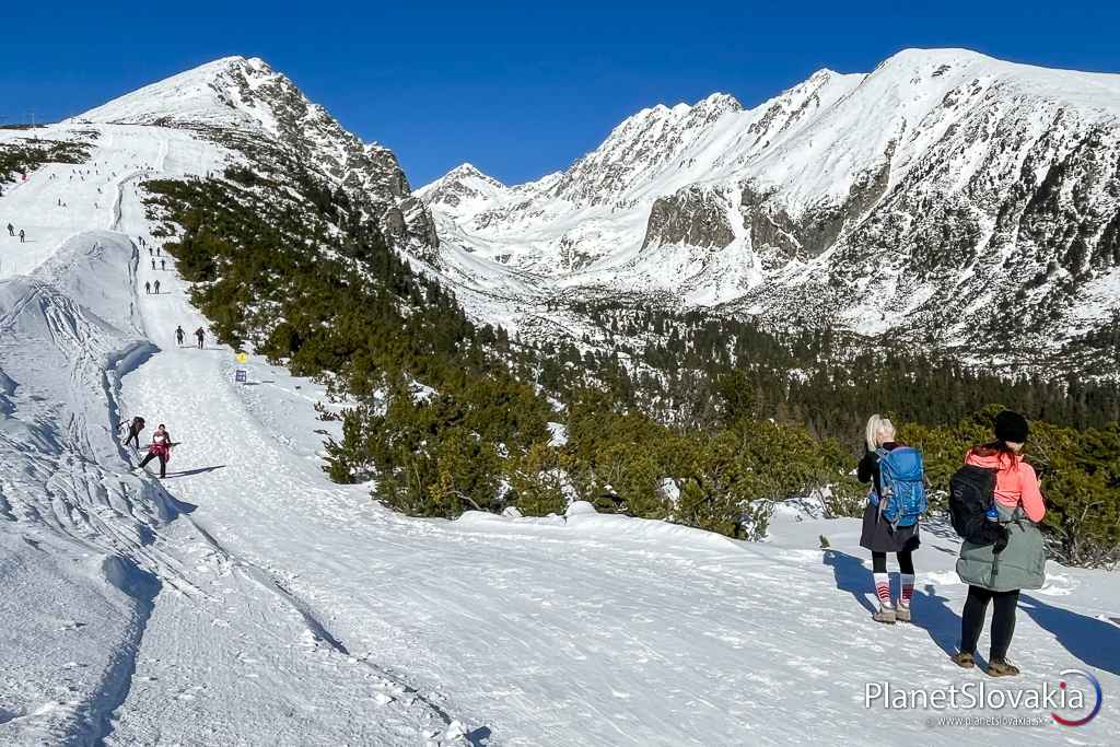 Turisti počas zimného výstupu na chatu pod Soliskom a Predné Solisko vľavo.