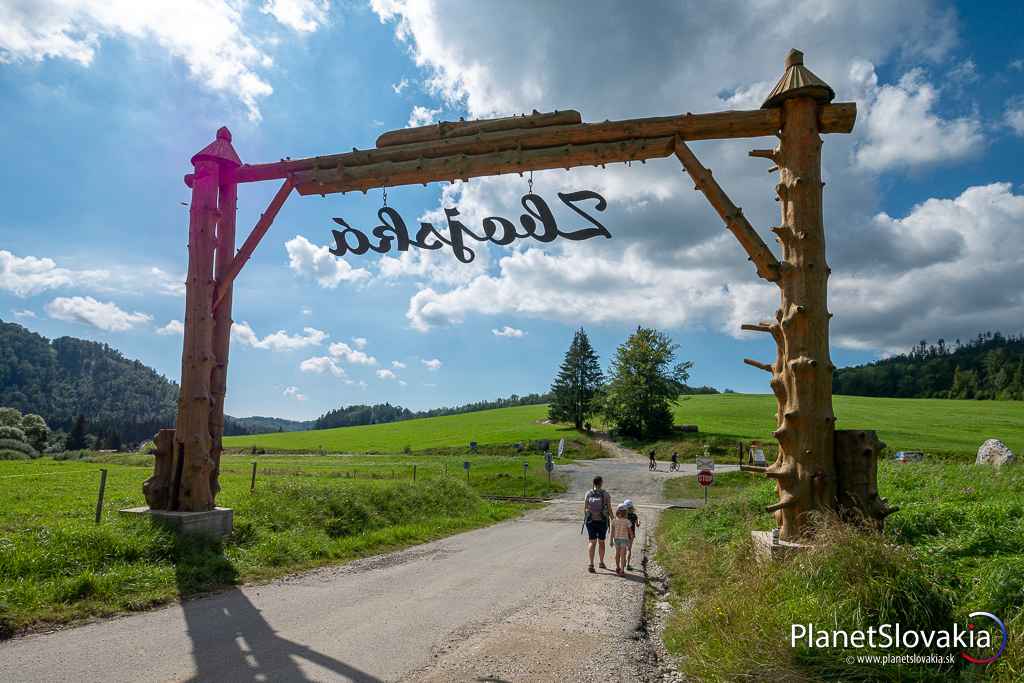 Vstupná brána salaša Zbojská. Na trávnatom kopci za stromami sa nachádza vyhliadková veža Zbojská.